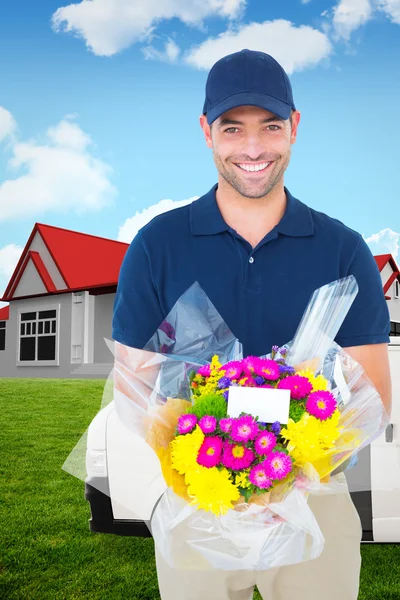 Composite image of happy delivery man holding bouquet — Stock Photo, Image