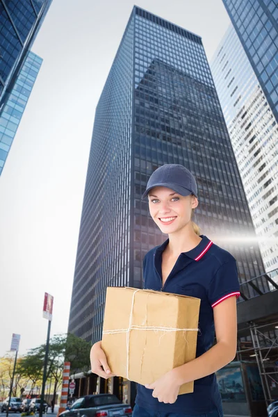 Image composite de femme de livraison heureuse tenant la boîte en carton — Photo