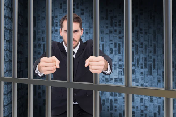 Composite image of businessman in prison — 图库照片