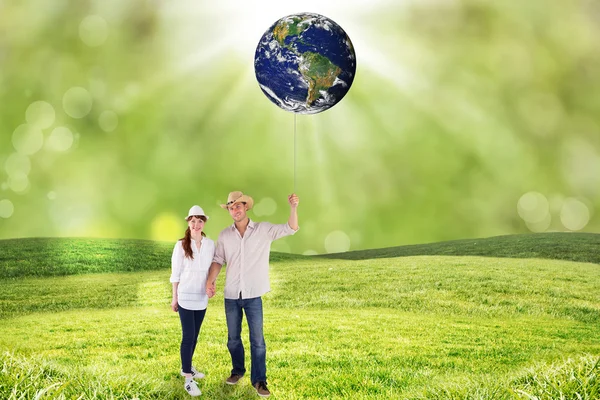 Couple both wearing hats against field — Stock Photo, Image