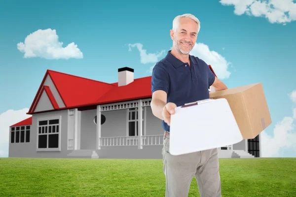 Composite image of happy delivery man holding cardboard box and — Stock Photo, Image