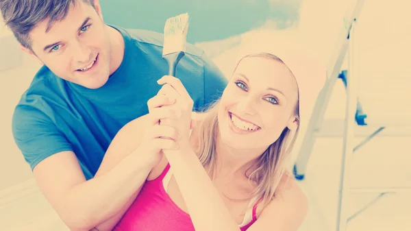 Casal se divertindo enquanto pinta uma sala — Fotografia de Stock