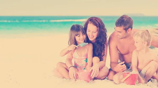 Familie sitzt am Strand — Stockfoto