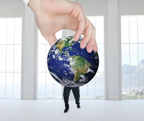 Hand holding earth and businessman — Stockfoto