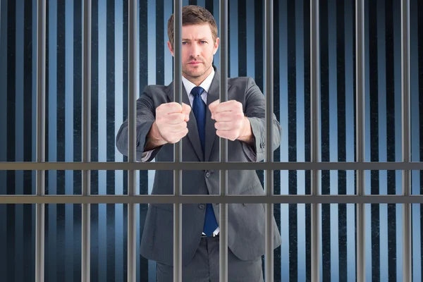 Composite image of businessman in prison — Stock Photo, Image