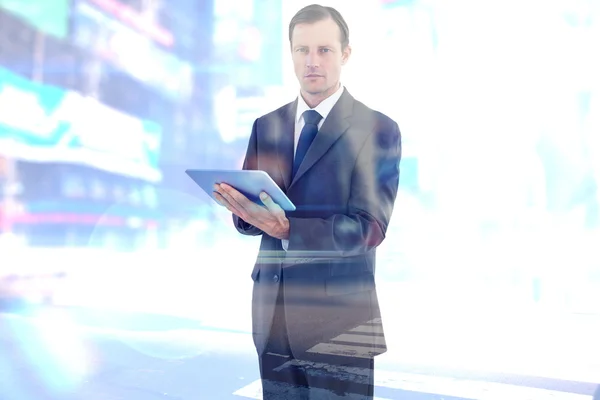 Serious charismatic businessman holding a tablet — Stock Photo, Image