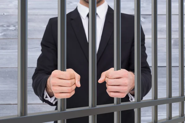 Composite image of businessman in prison — Stockfoto