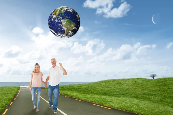 Imagen compuesta de pareja feliz caminando de la mano —  Fotos de Stock