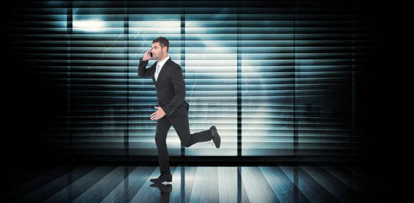 Composite image of businessman running on the phone — Stok fotoğraf