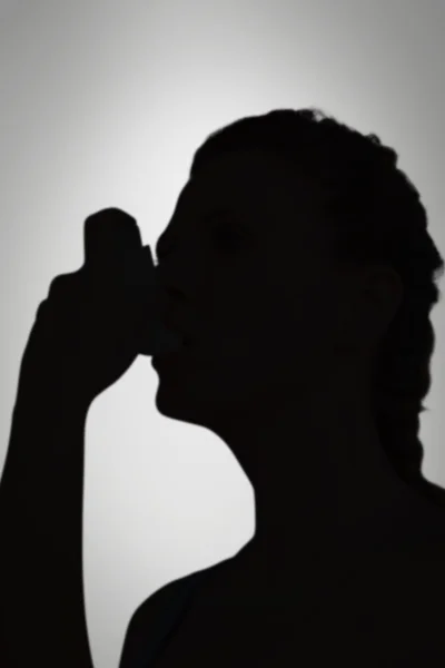Композитное изображение женщины, использующей ингалятор для лечения астмы — стоковое фото
