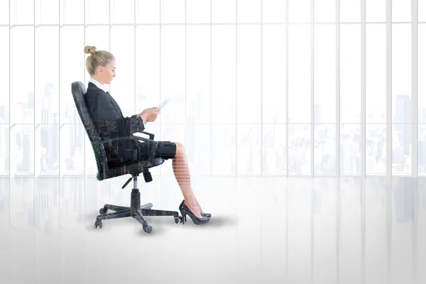 Businesswoman sitting on swivel chair with tablet — Stock Photo, Image