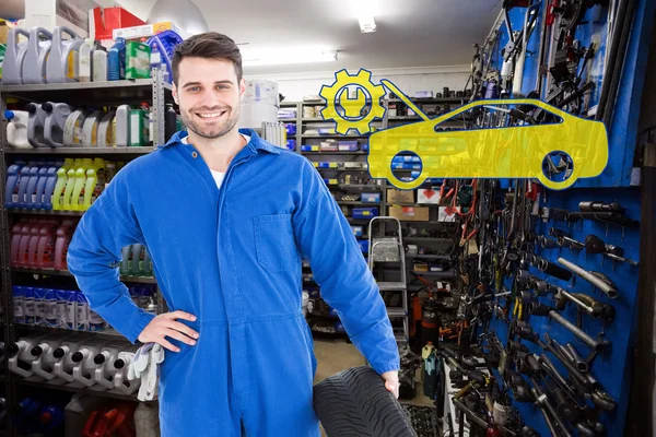 Mecánico sonriente sosteniendo neumático — Foto de Stock