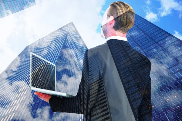 Composite image of businessman looking up holding laptop — Stock Photo, Image