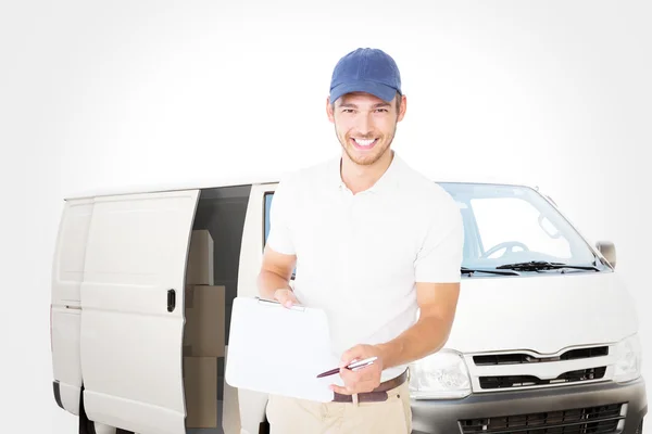 Composite image of happy delivery man holding clipboard — Stock Photo, Image