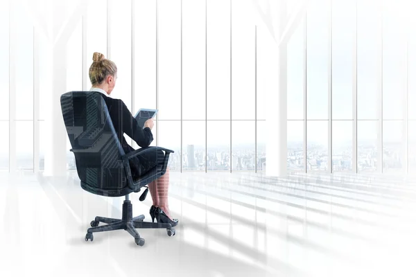 Businesswoman sitting on swivel chair with tablet — Stock Photo, Image