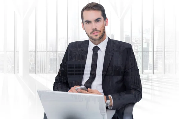 Vrolijke zakenman met laptop gebruikend smartphone — Stockfoto