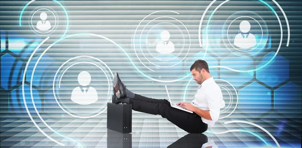 Composite image of businessman with feet up on briefcase — Stock Photo, Image