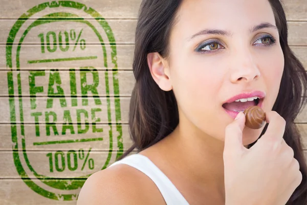 Composite image of pretty brunette eating chocolate candy — Φωτογραφία Αρχείου