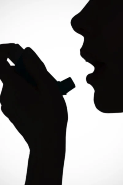Close up of a woman using an asthma inhaler — Stock Photo, Image