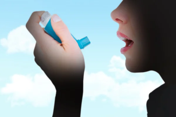 Composite image of close up of a woman using an asthma inhaler — ストック写真