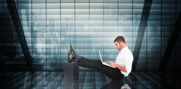 Composite image of businessman with feet up on briefcase — Stock Photo, Image