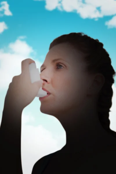 Composite image of woman using inhaler for asthma — Stok fotoğraf