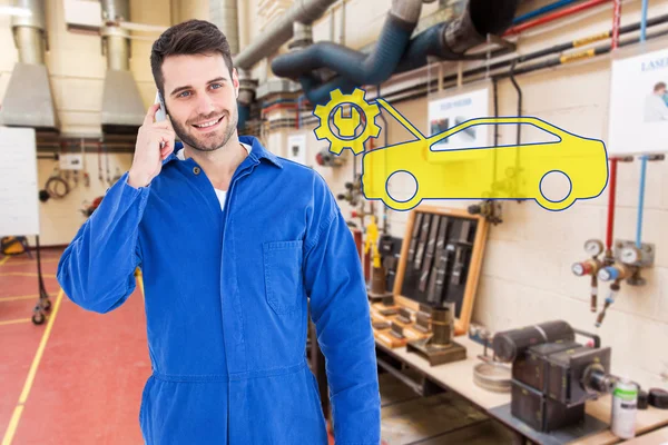 Lachende mannelijke mechanic met behulp van mobiele telefoon — Stockfoto