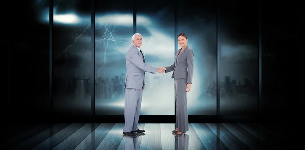 Composite image of business team shaking hands — Stockfoto