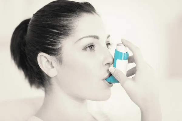 Woman using an asthma inhaler — Stock Photo, Image