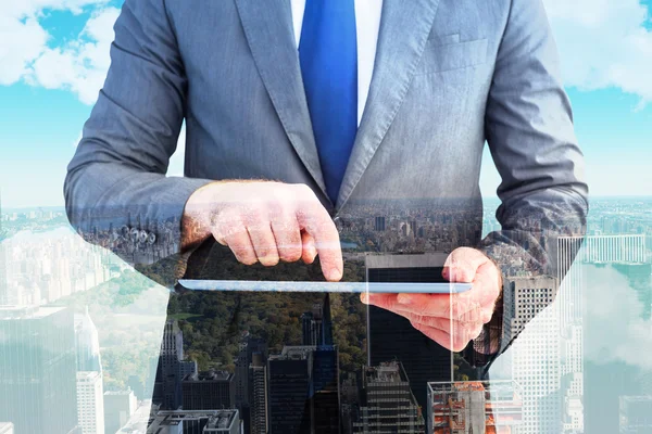 Composite image of businessman using his tablet pc — Stock Photo, Image