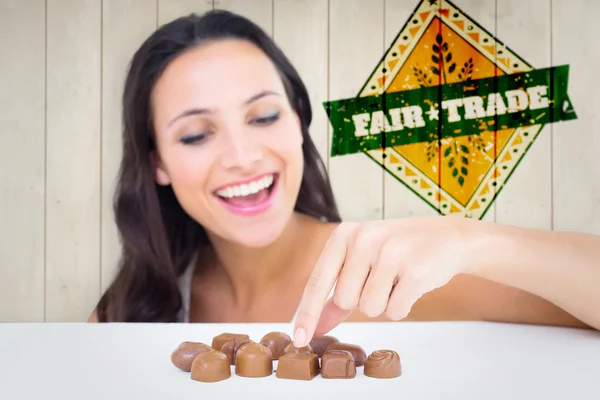 Pretty brunette picking out chocolate — Stock Photo, Image