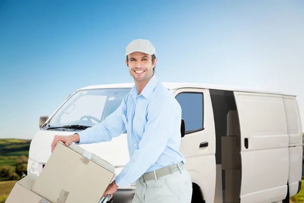 Confident delivery man pushing trolley of car — Stockfoto