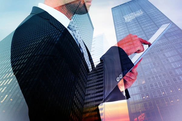 Composite image of businessman using his tablet pc — Stock Photo, Image