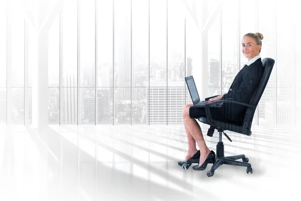 Mujer de negocios sentada en silla giratoria con portátil —  Fotos de Stock