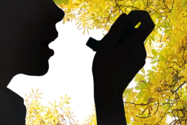 Close up of a woman using an asthma inhaler — Stock Photo, Image