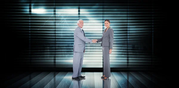 Composite image of business team shaking hands — Stockfoto
