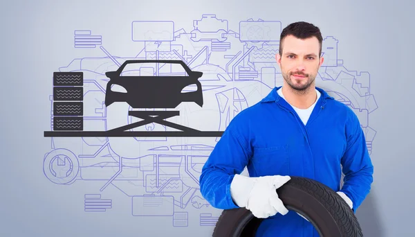 Male mechanic holding tire — Stock Photo, Image