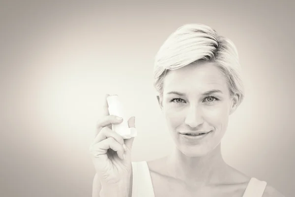 Bonita mujer sosteniendo inhalador sonriendo a camer —  Fotos de Stock