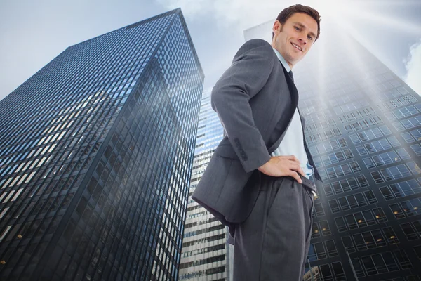 Imagen compuesta de un hombre de negocios alegre de pie — Foto de Stock