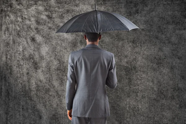 Imagem composta de empresário de pé sob guarda-chuva — Fotografia de Stock