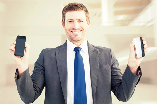 Businessman holding two smart phones — Stock Photo, Image