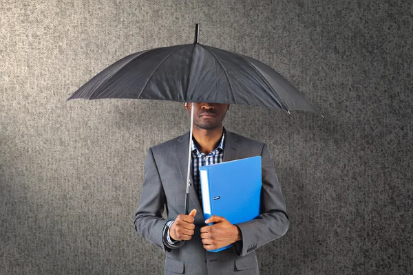 Composite image of businessman standing under umbrella — Stock Photo, Image