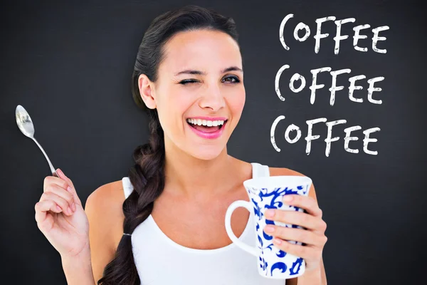 Composite image of pretty brunette having cup of tea — Stock Photo, Image