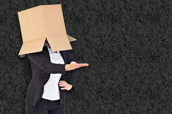 Composite image of businesswoman presenting with box over head — Stock Photo, Image