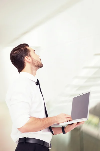 Hombre de negocios de pie usando un ordenador portátil — Foto de Stock