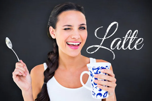 Composite image of pretty brunette having cup of tea — Stock Photo, Image