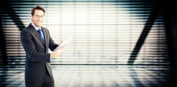 Businessman looking at the camera while using — Stock Photo, Image