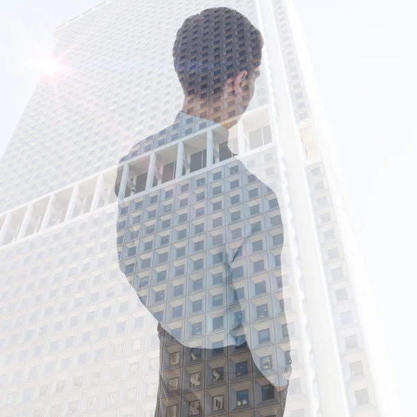 Composite image of businessman standing with hands in pockets — Stock Photo, Image