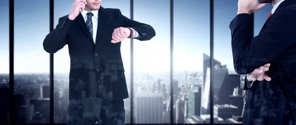 Businessman phoning while checking time — Stock Photo, Image