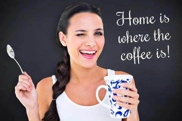 Composite image of pretty brunette having cup of tea — Stock Photo, Image